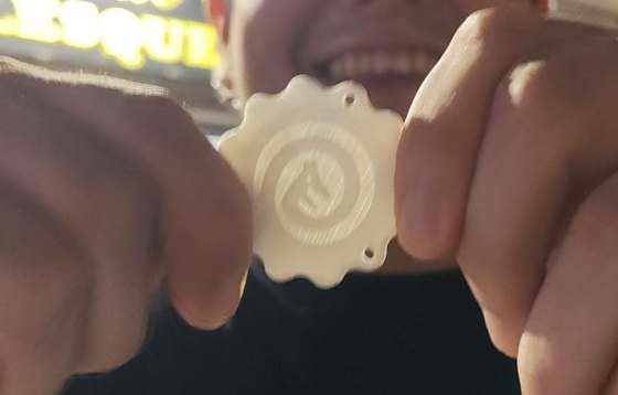 Orticoin blanco sostenido entre dos dedos